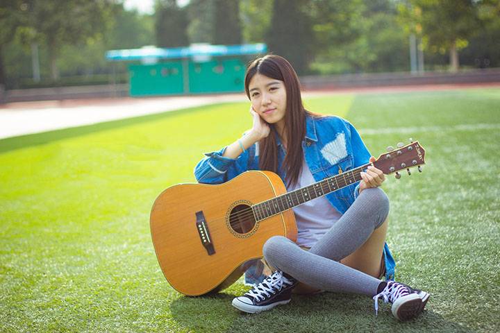 户外阳光下的吉他少女